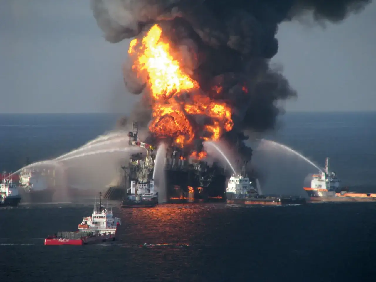 Płonąca platforma wiertnicza Deepwater Horizon, otoczona statkami gaśniczymi próbującymi opanować pożar.