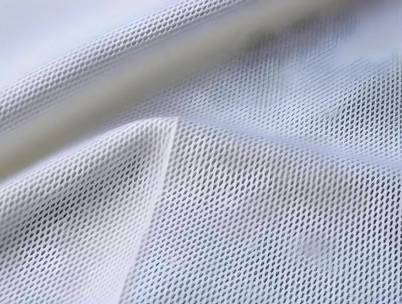 Close-up of white mesh fabric, showcasing its intricate weave. This most breathable fabric allows air to flow freely, keeping you cool and comfortable.