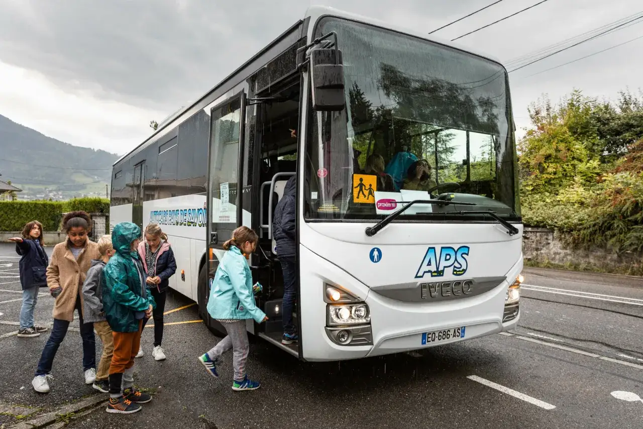 Des enfants montent dans un bus pour un voyage scolaire, une aide du conseil général rendant cela possible.