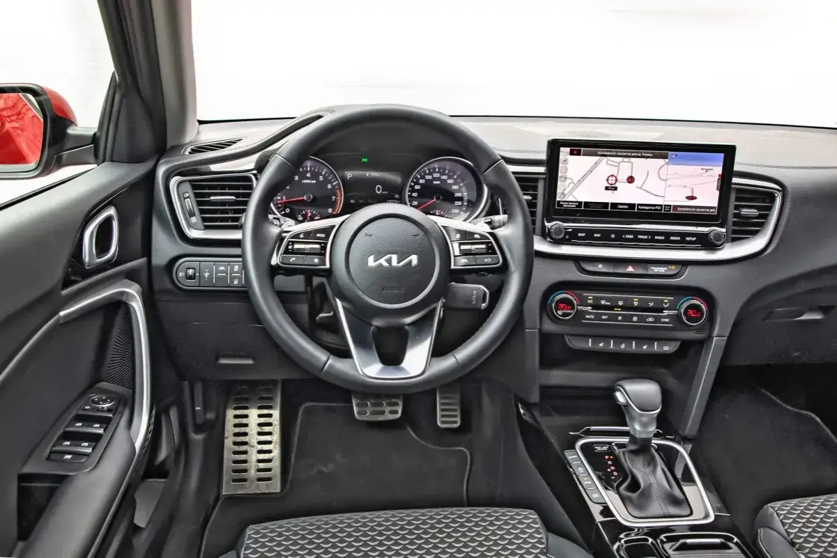 Wnętrze Kia Ceed 1.5 T-GDI: kierownica, nawigacja, panel klimatyzacji i skrzynia biegów.