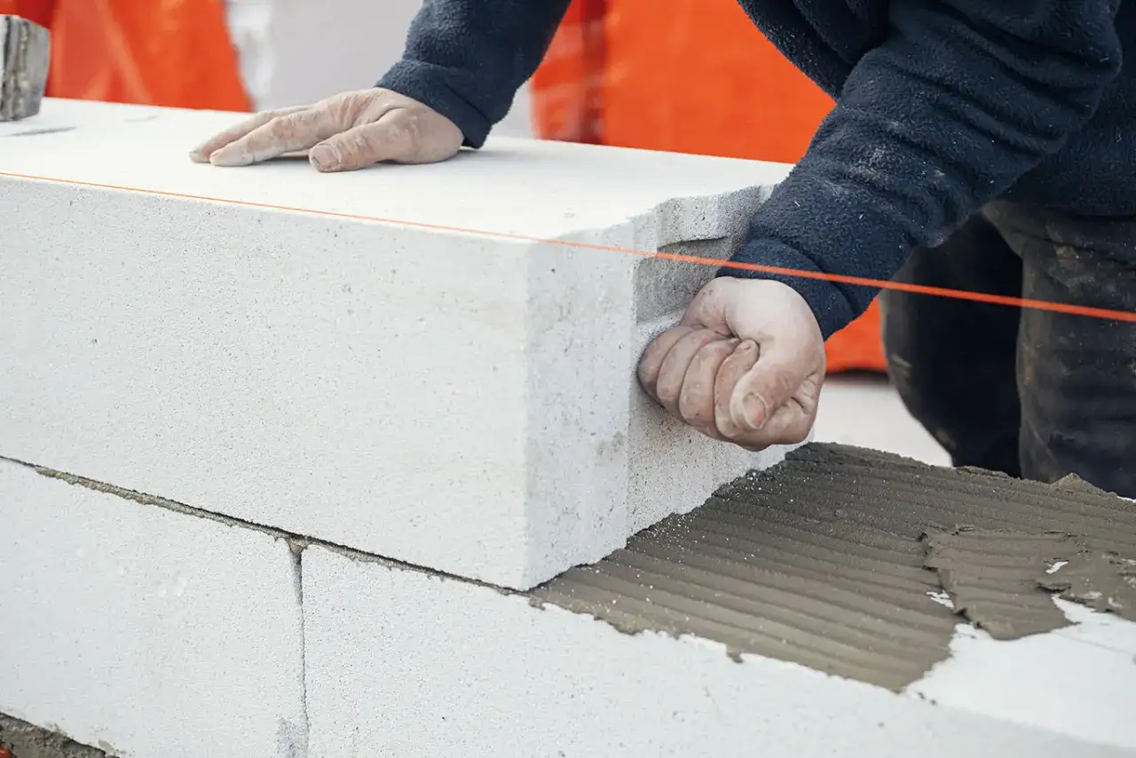 Pose d'un mur en béton cellulaire. Attention à l'humidité qui peut affecter la pose et la durabilité.