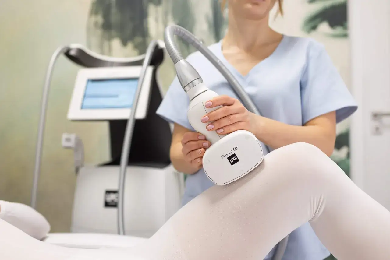 Zabieg endermologii co to? Terapeuta wykonuje zabieg na udzie pacjentki za pomocą urządzenia LPG Alliance 50.