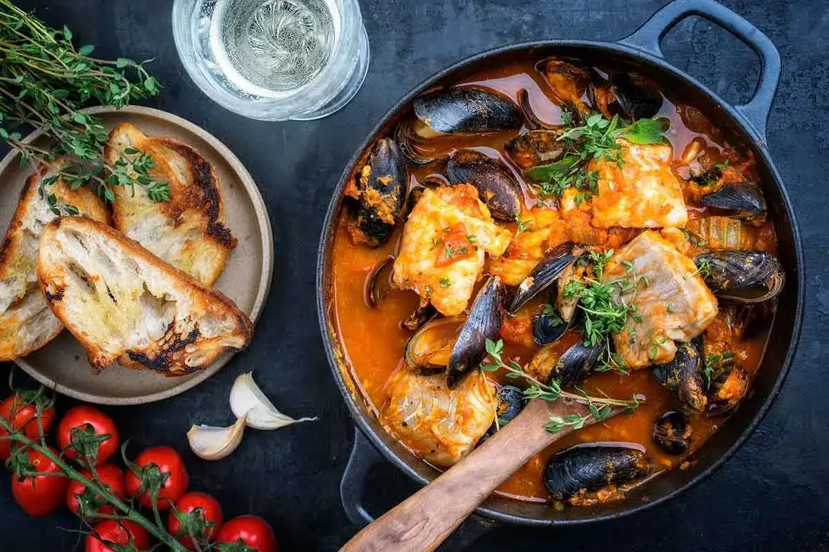 Ricca zuppa di pesce surgelato con cozze, pesce bianco e pane tostato.
