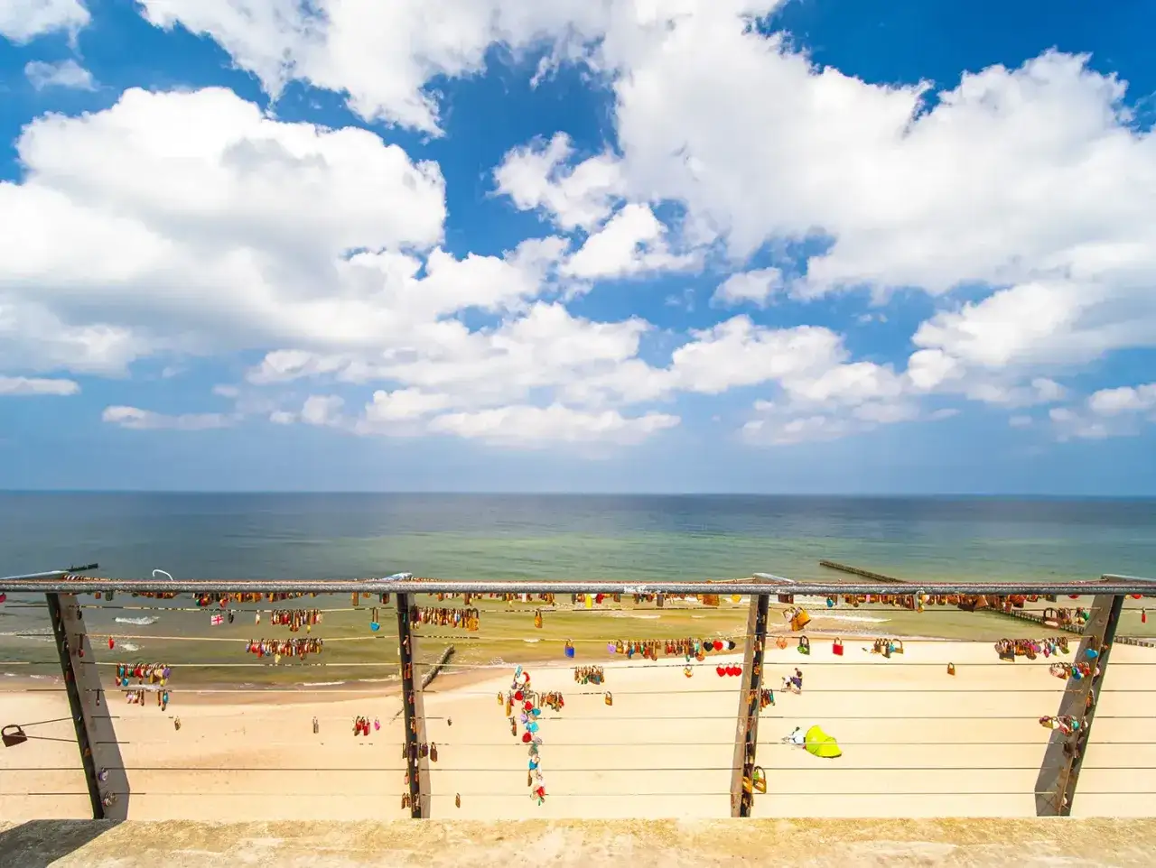 Kł&oacute;dki miłości na balustradzie z widokiem na morze i plażę. Jedna z rewal atrakcje, kt&oacute;ra przyciąga zakochanych.