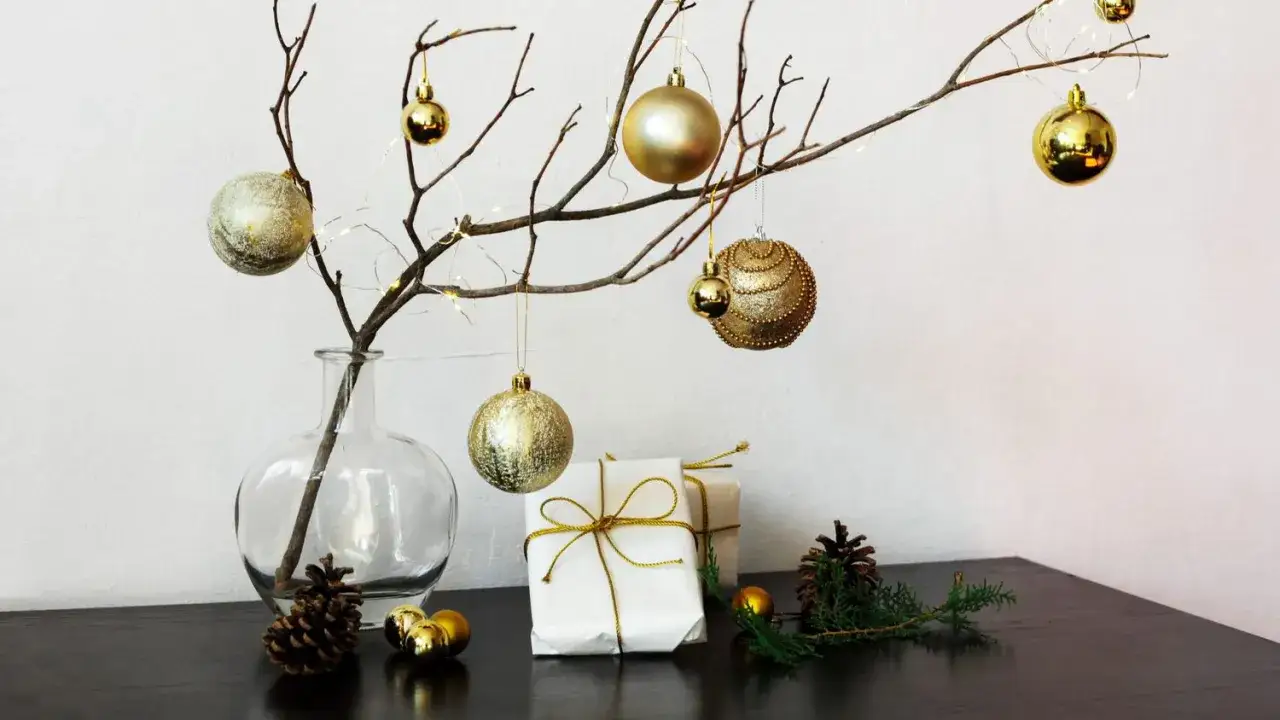 Zarte Äste in einer Vase, geschmückt mit goldenen Kugeln und Lichterketten, bieten stilvolle alternativen zum weihnachtsbaum.