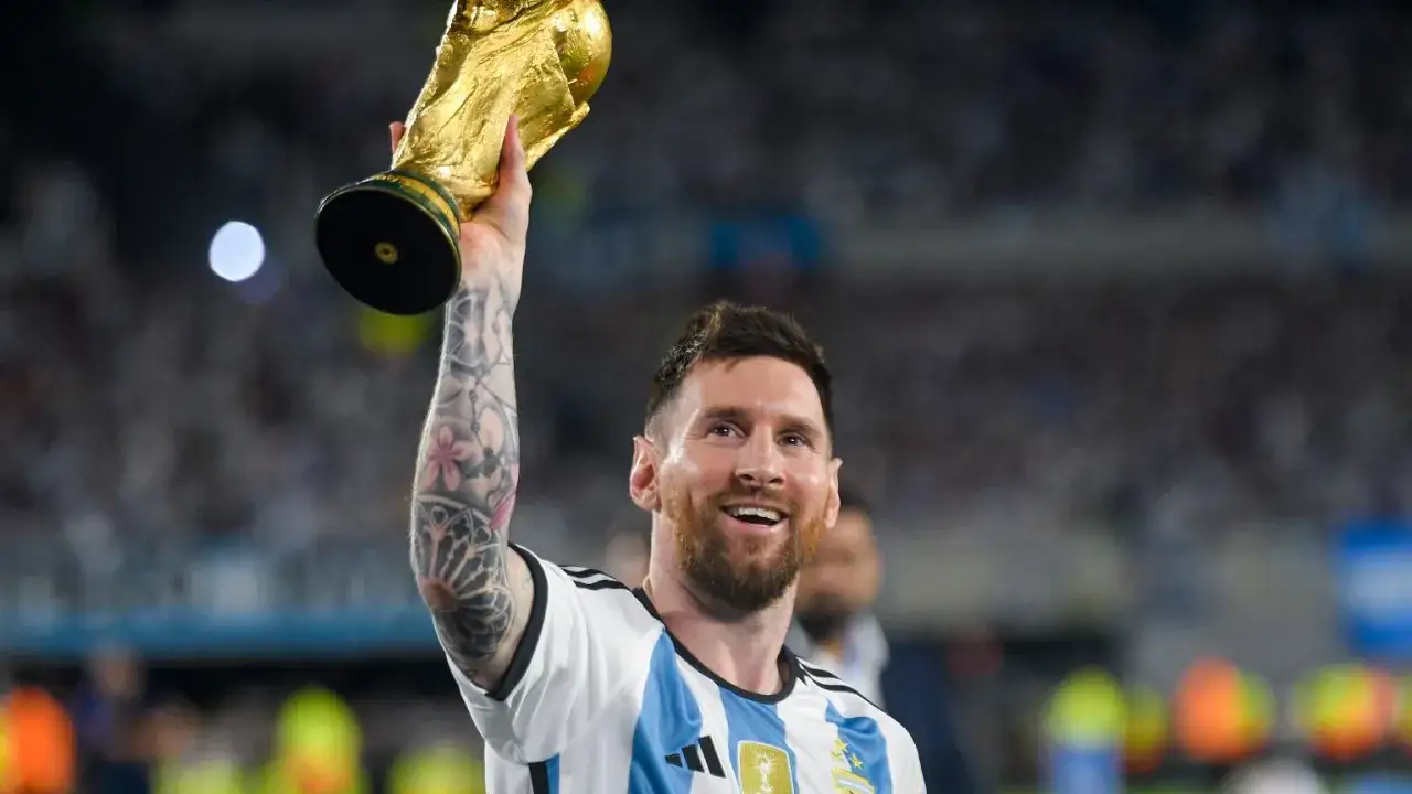 Uśmiechnięty Messi z Pucharem Świata, symbol triumfu reprezentacji Argentyny.