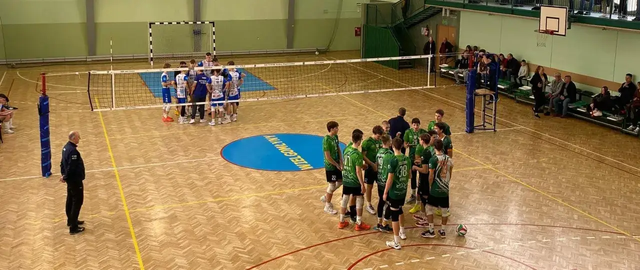 Drużyny siatkarzy przed meczem, zastanawiają się, ile trwa mecz siatkówki. Na boisku panuje napięcie.