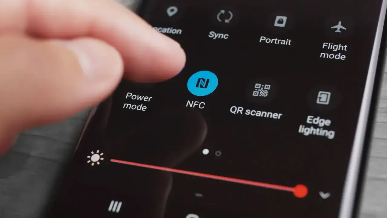 Dedo tocando el icono de NFC para activar NFC en Android.