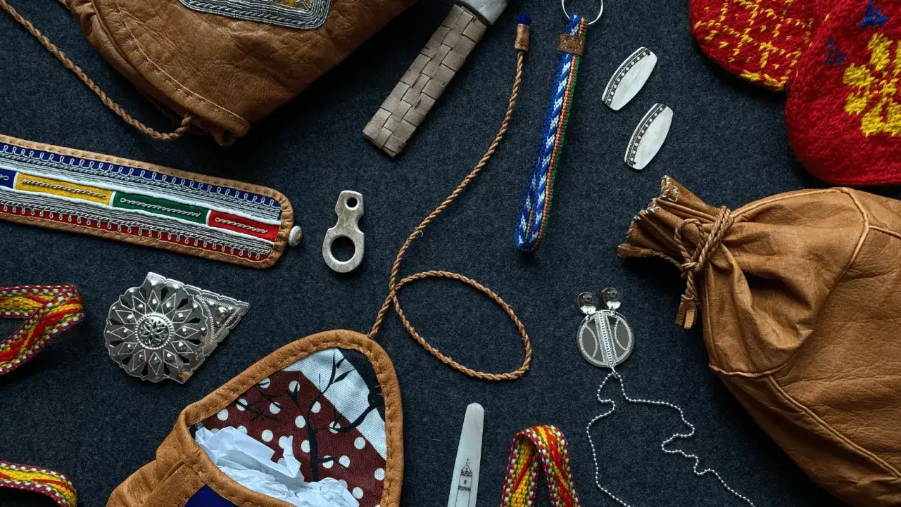 Samiska smycken med stor betydelse: en läderpåse, en broderad manschett, silverdetaljer och vävda band.