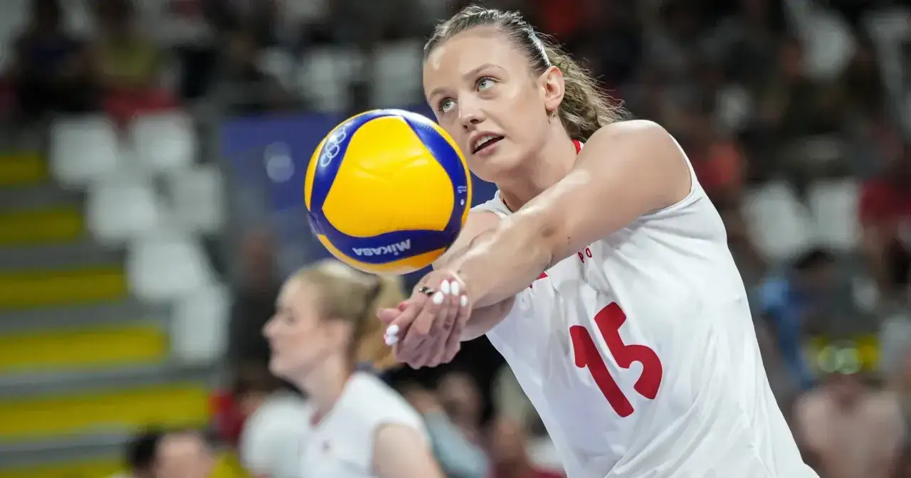 Martyna Czyrniańska, zawodniczka z numerem 15, odbija piłkę do siatk&oacute;wki. Jej wzrost pozwala na skuteczną grę.