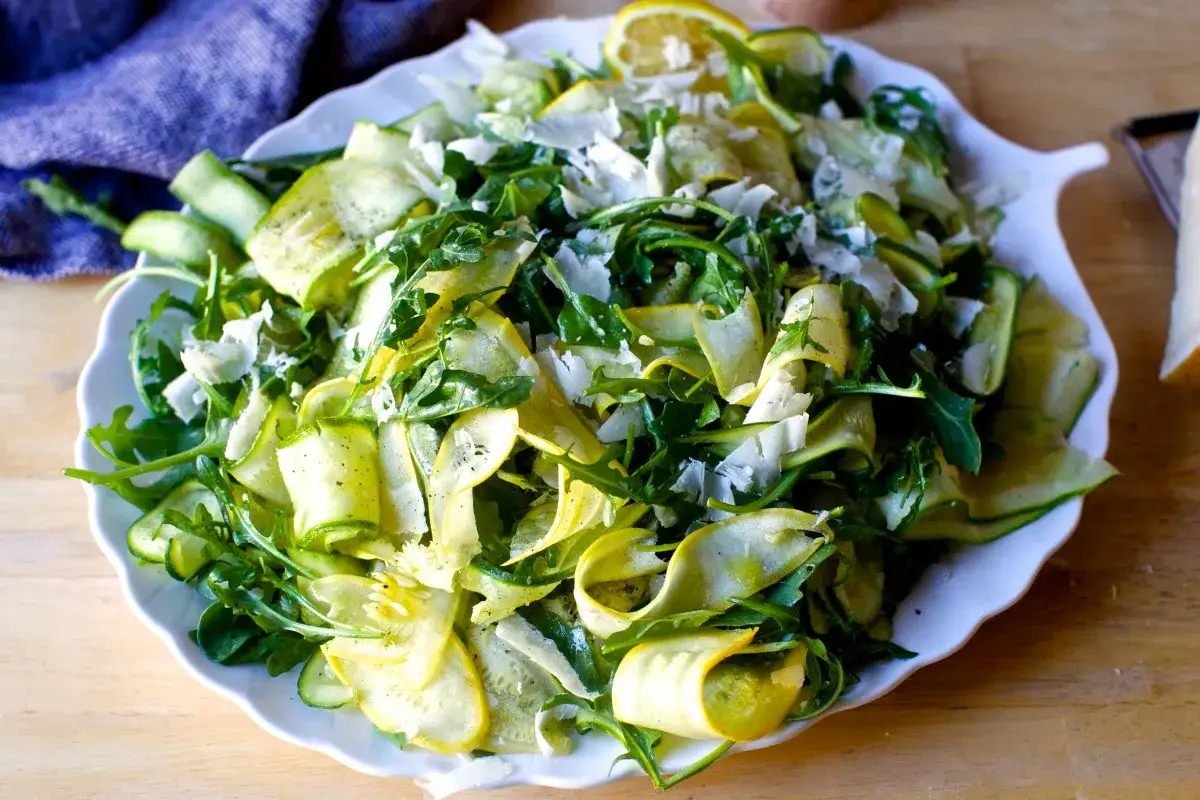 Frischer Salat mit dünnen Zucchinischeiben, Rucola und Parmesan. Perfekt, um Zucchini roh zu essen!