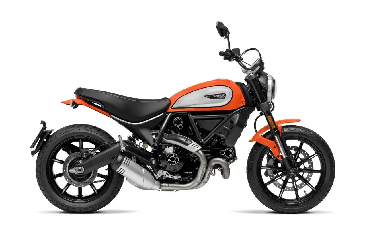Pomarańczowy motocykl Ducati Scrambler, idealny dla dziewczyny 160 cm wzrostu. Stylowy i zwinny, gotowy na przygodę.