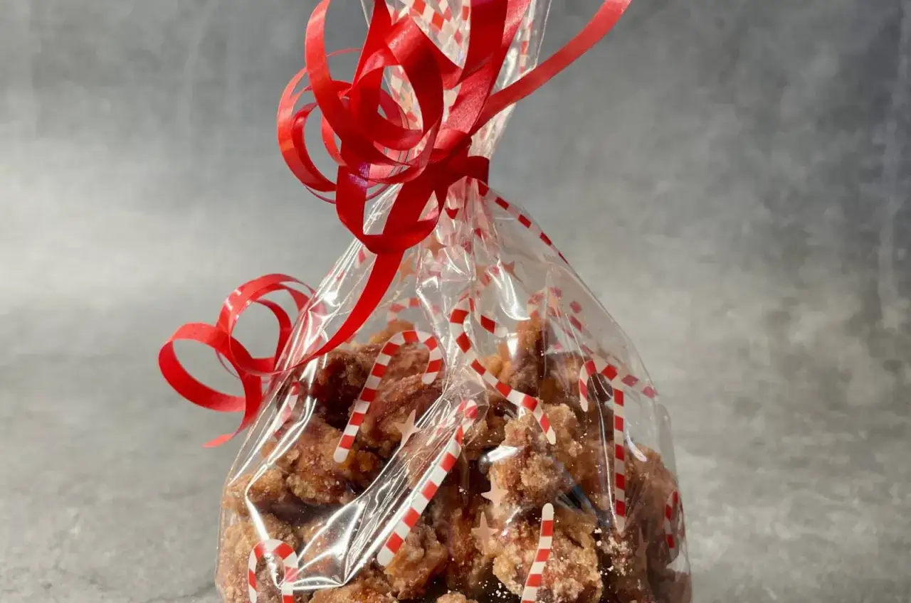 Ein Beutel mit gebrannten Mandeln, verziert mit Zuckerstangen-Motiven und roter Schleife. Perfekt f&uuml;r die Schwangerschaft!