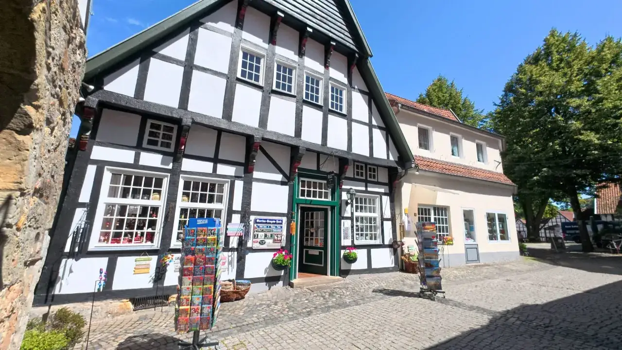 Fachwerkhaus in der Tecklenburger Altstadt mit Gesch&auml;ften und Postkartenst&auml;ndern.