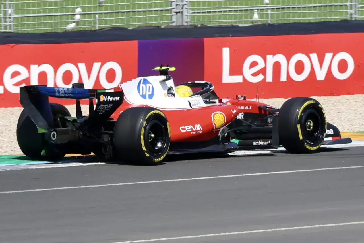 Monoplaza de **f&oacute;rmula 1 Ferrari** rojo y blanco con logo de HP, compitiendo en circuito.