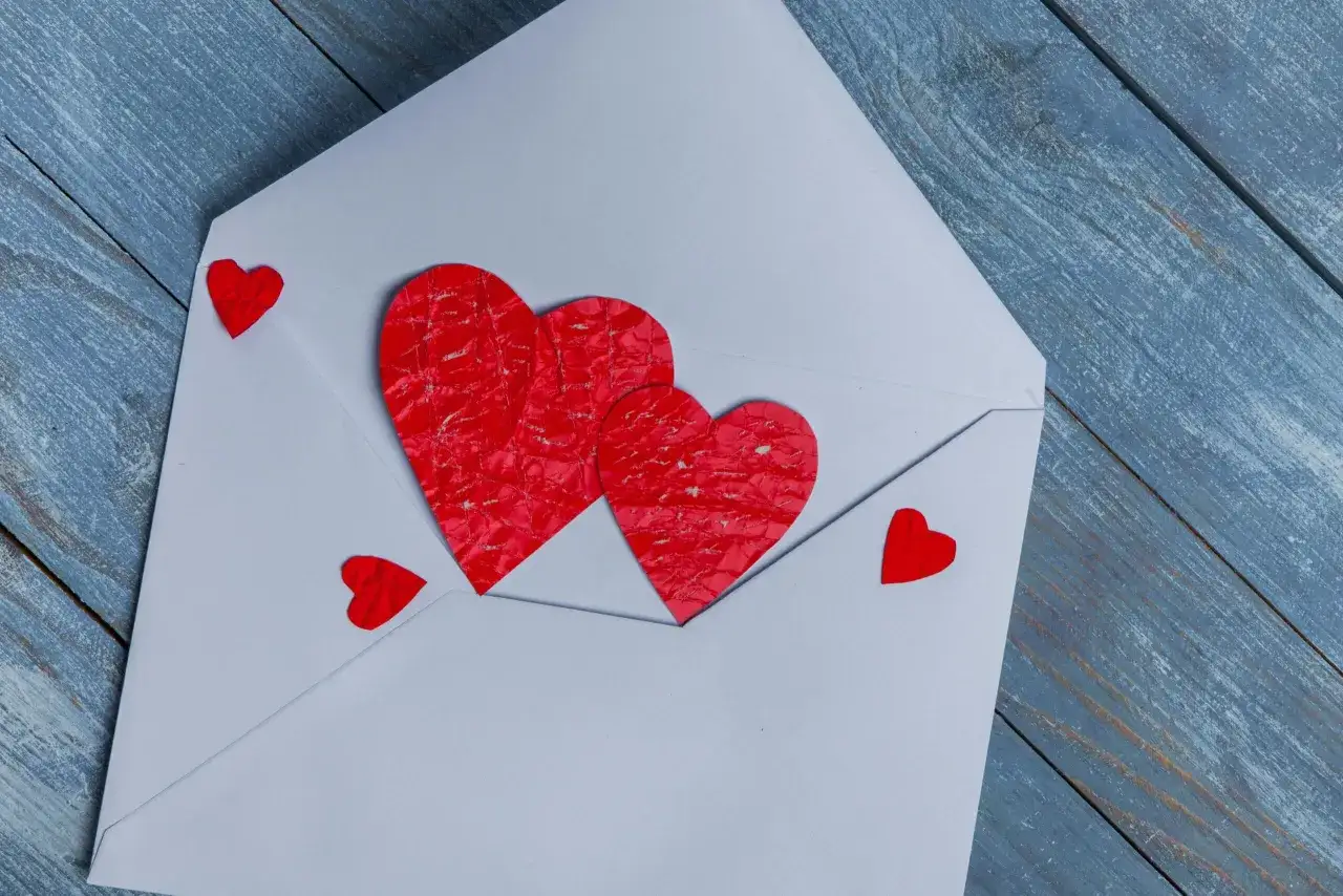 Biała koperta z czerwonymi serduszkami, jakby zapowiedź nadchodzącego **love bombing**.
