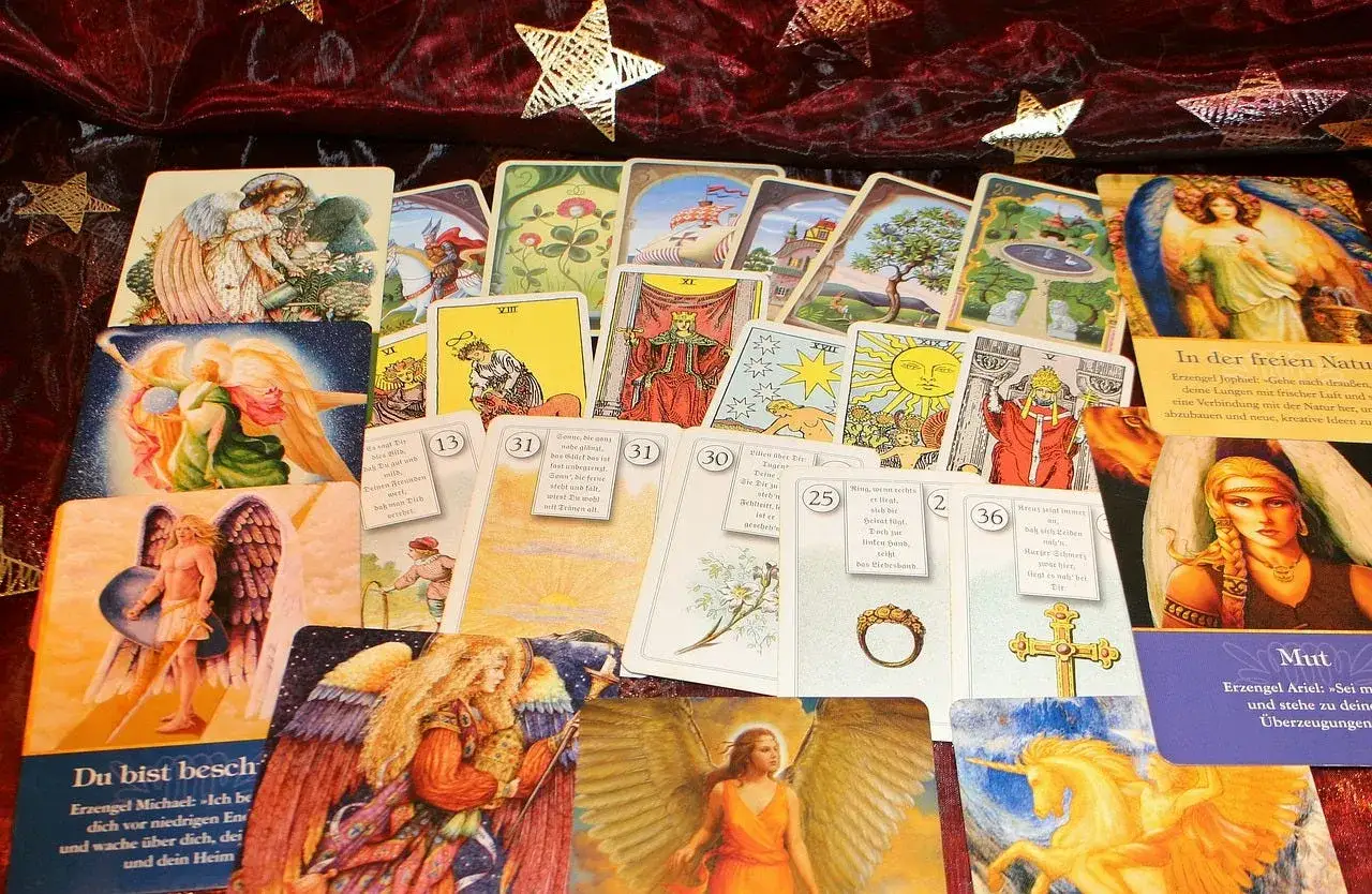 Tarot y or&aacute;culo: cartas con &aacute;ngeles y s&iacute;mbolos m&iacute;sticos, algunas con texto en alem&aacute;n, sugieren una diferencia en su uso para la adivinaci&oacute;n.