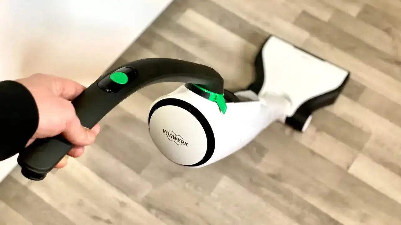 Hand hält den Vorwerk SP 600 auf Holzboden. Mögliche Nachteile bei der Handhabung sind hier nicht ersichtlich.