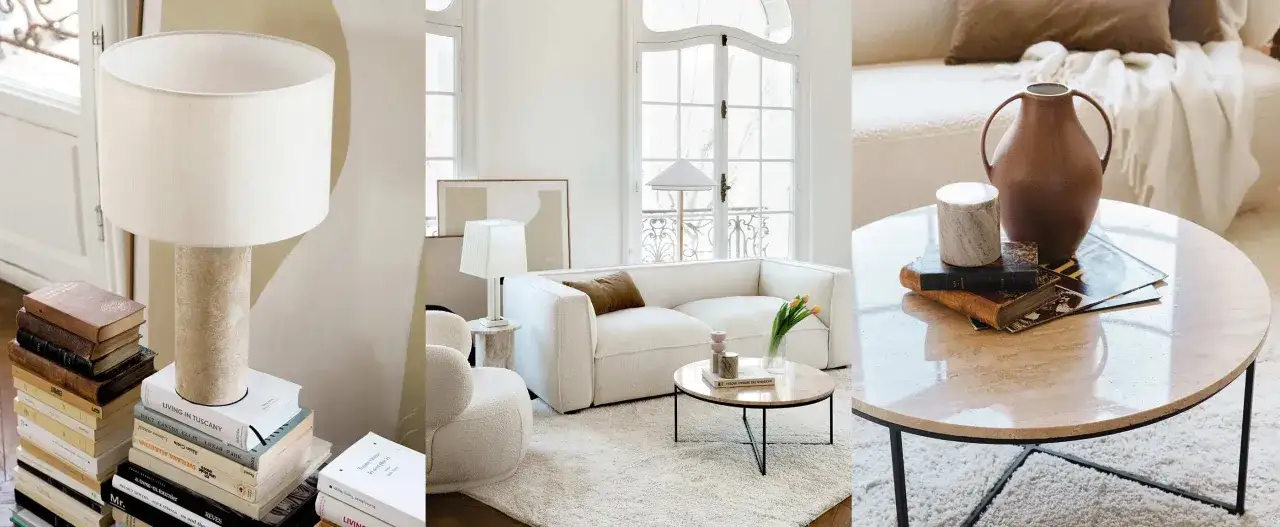 Un salon sans meuble TV, avec un canap&eacute; blanc, des lampes, des livres et une table basse en marbre.