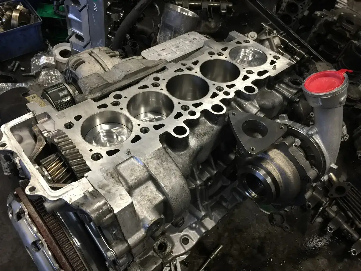 Rozłożony silnik VW Touareg 2.5 TDI R5. Widać turbosprężarkę, blok silnika z cylindrami i wał korbowy.