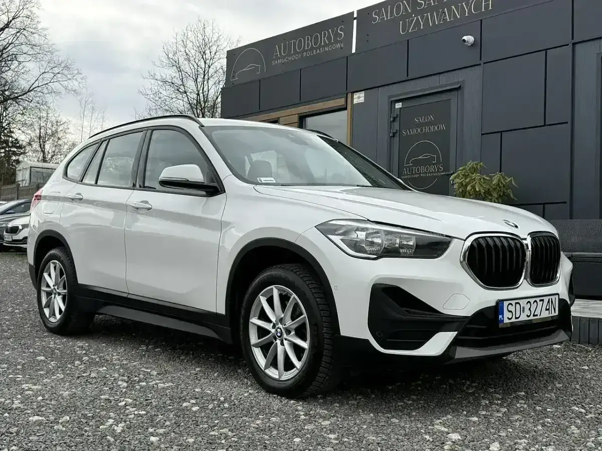 Białe BMW X1 przed salonem samochodowym. Sprawdź aktualną bmw x1 cena i ofertę.
