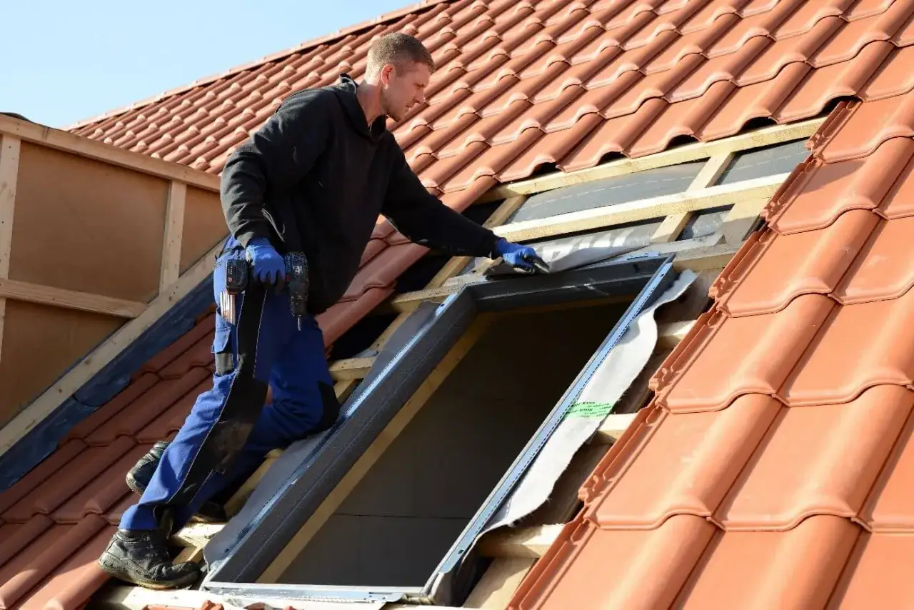 Handwerker installiert Dachfenster. Informieren Sie sich &uuml;ber den Dachfenster Zuschuss f&uuml;r Ihr Projekt.