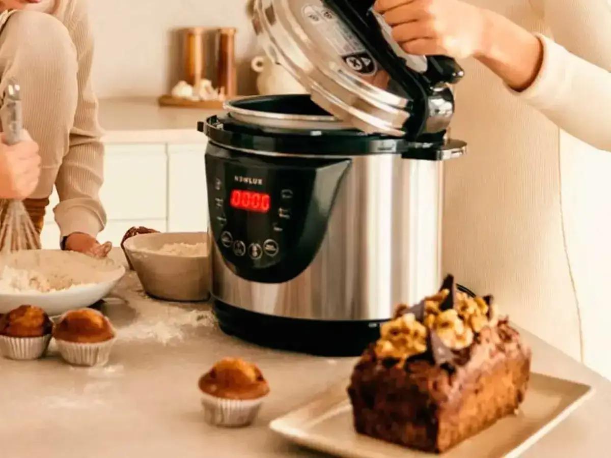Una olla express moderna y un bizcocho decorado. Descubre la diferencia entre olla express y olla a presión para tus recetas.