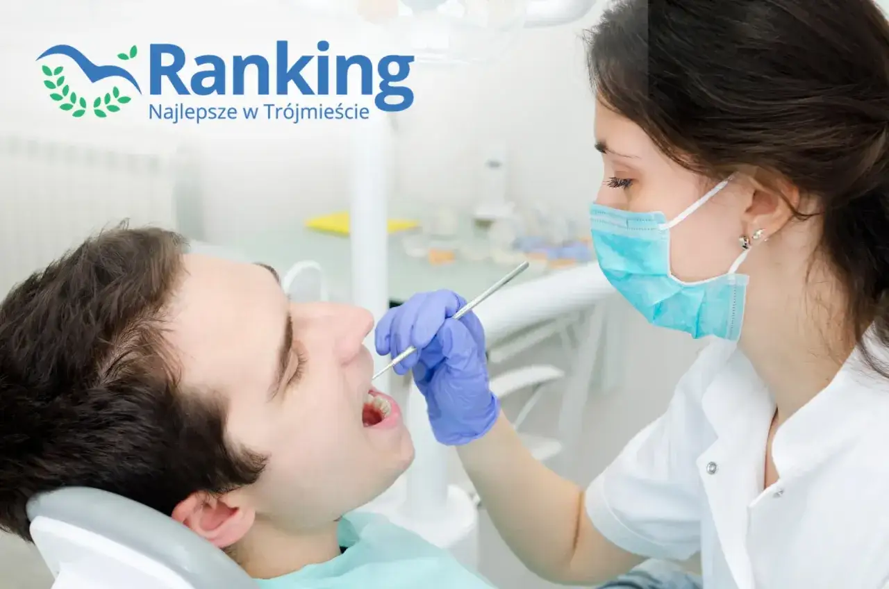 Dentystka w masce bada zęby pacjenta narzędziem stomatologicznym.