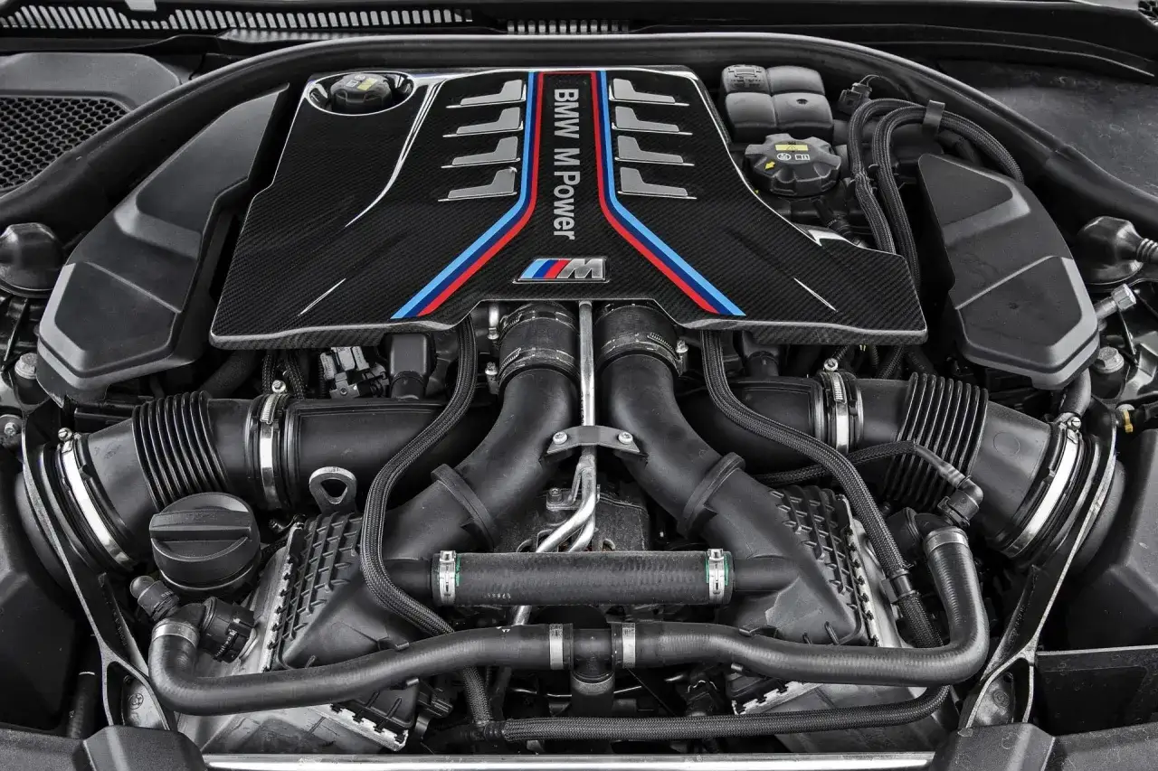 Potężny silnik V8 z BMW M5 G30, ozdobiony karbonową osłoną z kultowymi barwami M Power.