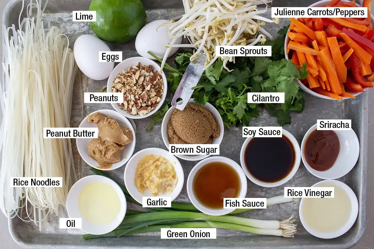 Ingredienser f&ouml;r en smakrik pad thai s&aring;s: risnudlar, jordn&ouml;tssm&ouml;r, lime, &auml;gg, b&ouml;nskott, koriander, sriracha, sojas&aring;s, fisks&aring;s, risvin&auml;ger, vitl&ouml;k, socker, olja, jordn&ouml;tter, mor&ouml;tter, paprika och salladsl&ouml;k.