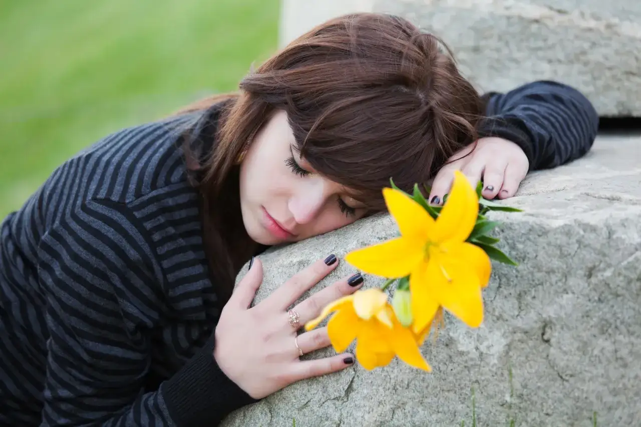 Ragazza con fiore giallo, triste, forse in attesa di un permesso per lutto suocero.