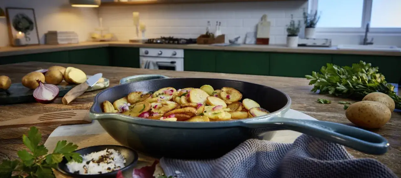 Bratkartoffeln in einer Pfanne, goldbraun gebraten, mit Zwiebeln und Kr&auml;utern verfeinert. Perfekt zum butterschmalz braten.