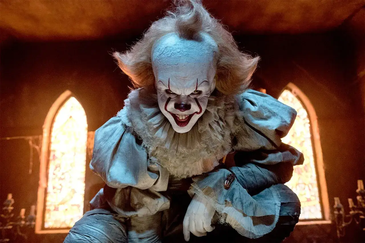 Gripsou le clown dansant, au maquillage effrayant et &agrave; la robe victorienne, se tient dans une pi&egrave;ce sombre avec des vitraux.