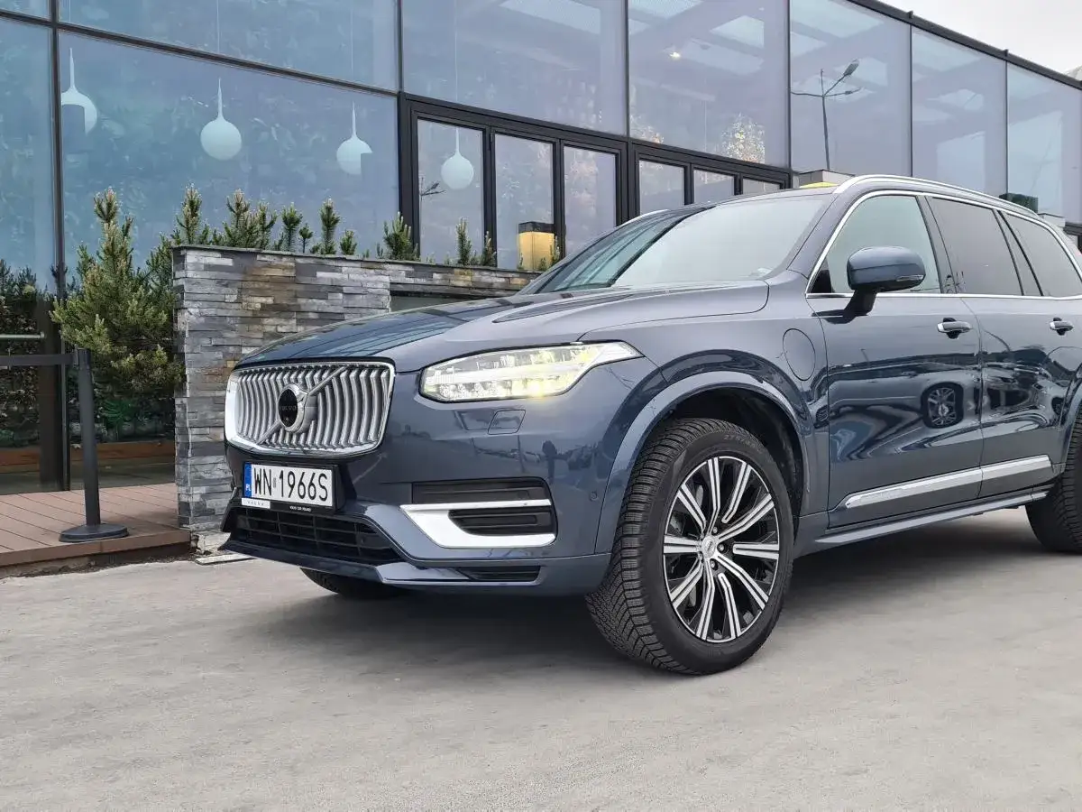 Szary Volvo XC90 przed nowoczesnym budynkiem. Zastanawiasz się, jaki silnik wybrać do tego SUV-a?