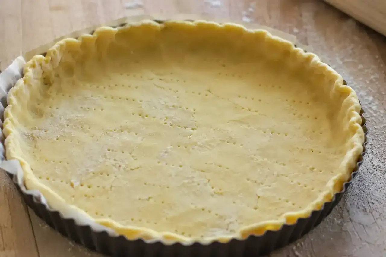 P&acirc;te bris&eacute;e sans beurre, pr&ecirc;te &agrave; &ecirc;tre garnie. Elle est joliment piqu&eacute;e et bord&eacute;e dans un moule &agrave; tarte.