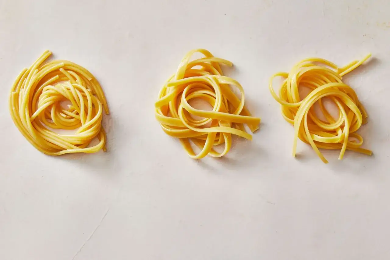 Trzy porcje makaronu: okrągłe gniazda spaghetti, płaskie fettuccine i tagliatelle, gotowe do sosu.