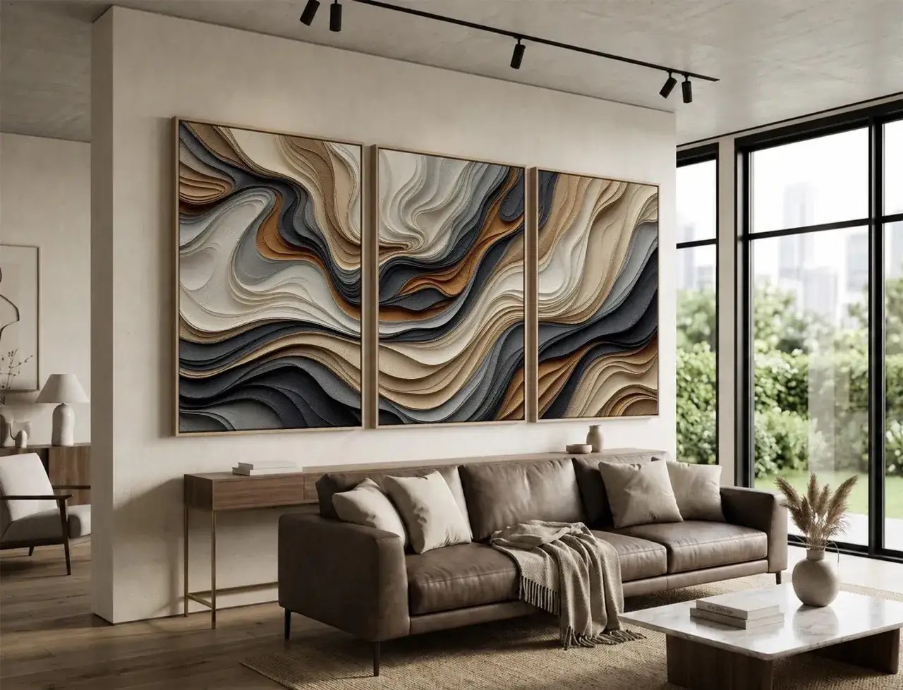 Un moderno salón con un sofá de cuero marrón y un marco triptico de arte abstracto en tonos tierra sobre la pared.
