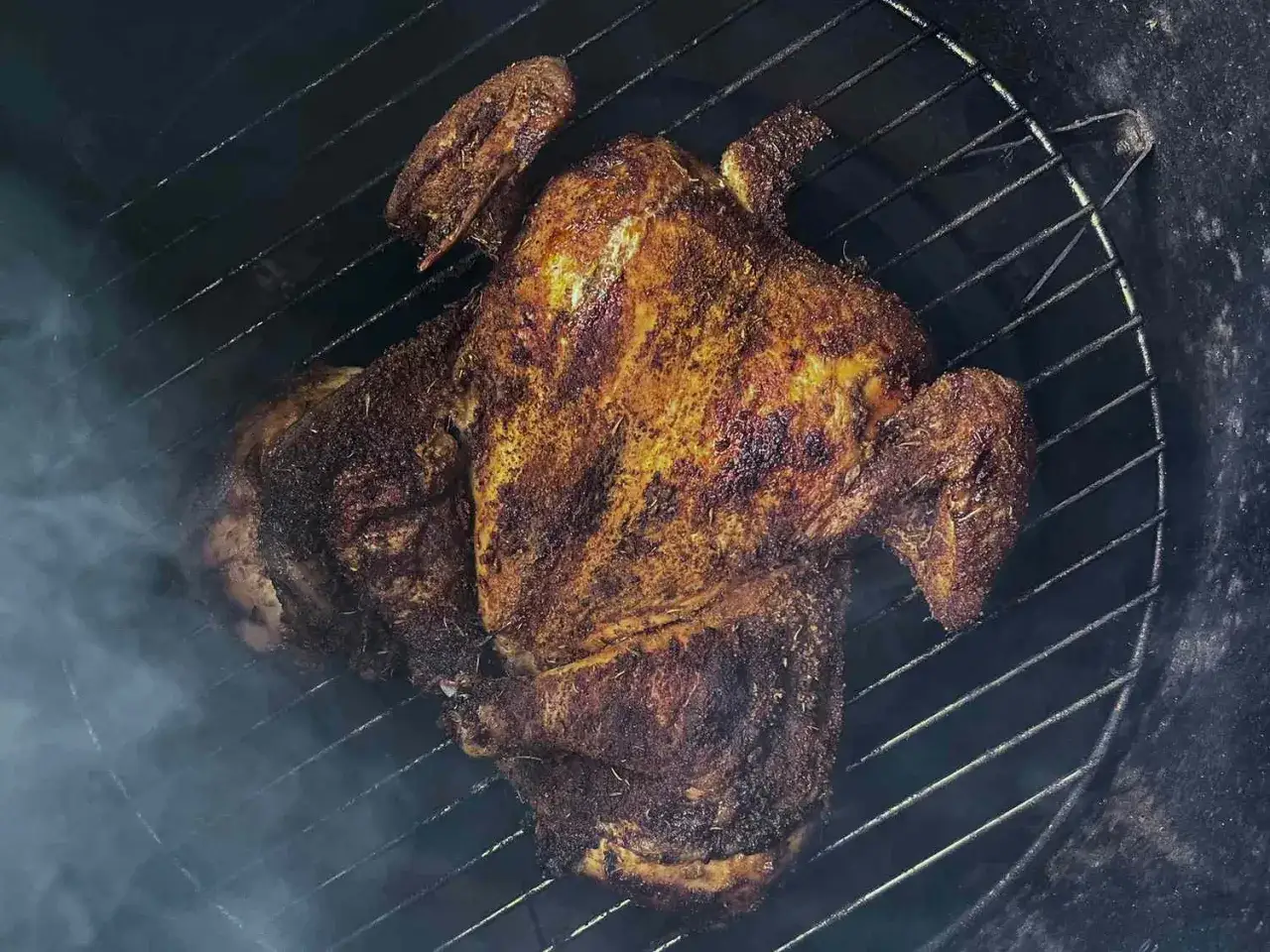 Un poulet fumé, prêt à être dégusté, sur une grille. Une recette savoureuse en préparation.