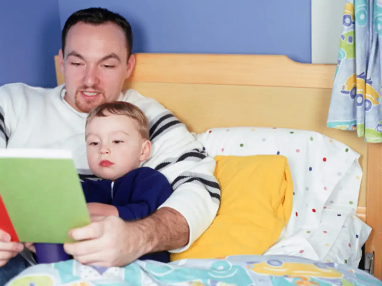 Padre legge favole della buonanotte da leggere al suo bambino, accoccolati a letto.
