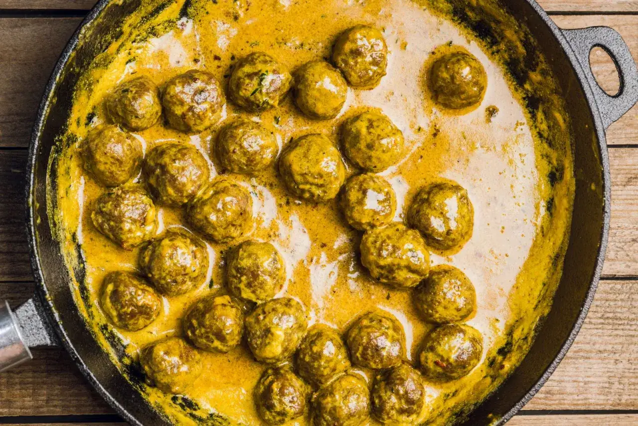 Polpette in bianco cremose in padella, un piatto invitante e saporito, pronte per essere gustate.