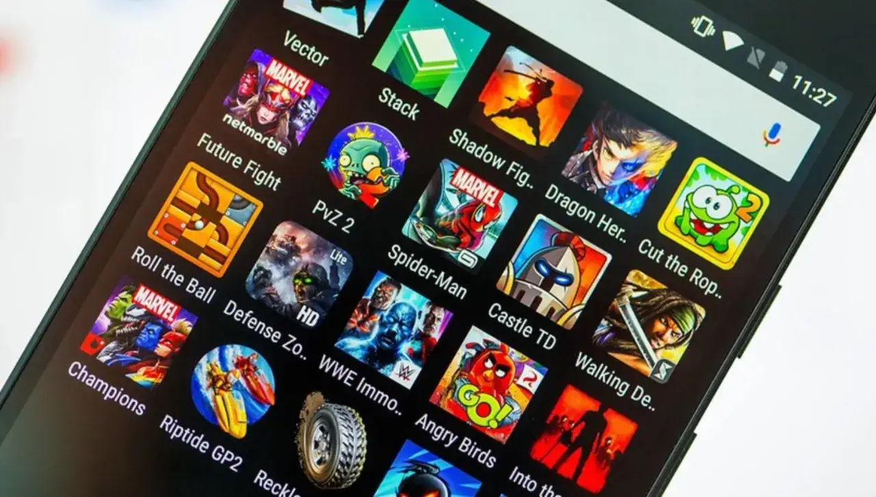 Ekran telefonu z ikonami gier. Znajdziesz tu wiele tytułów, w tym te z serii Marvel, Plants vs. Zombies, Angry Birds i inne, idealne do grania w stare gry na telefon za darmo.