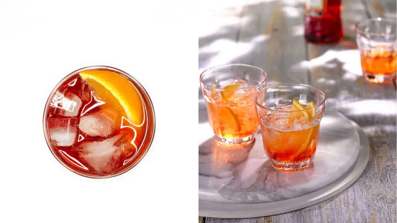 Aperol kontra Campari: dwa drinki z pomarańczą i lodem. Jeden z góry, dwa na marmurowej desce.