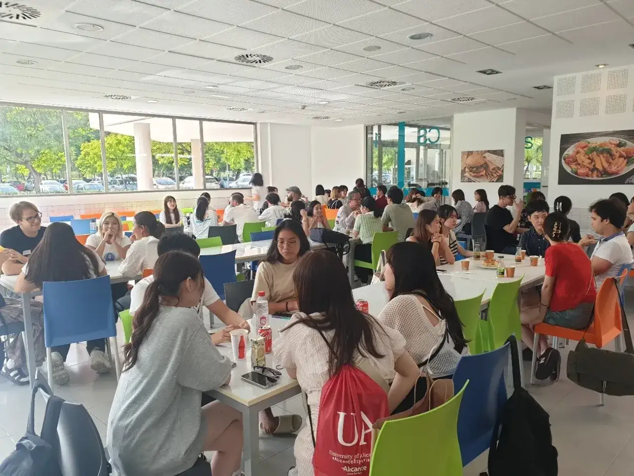 Des étudiants discutent et mangent dans la cafétéria de l'université d'Alicante.