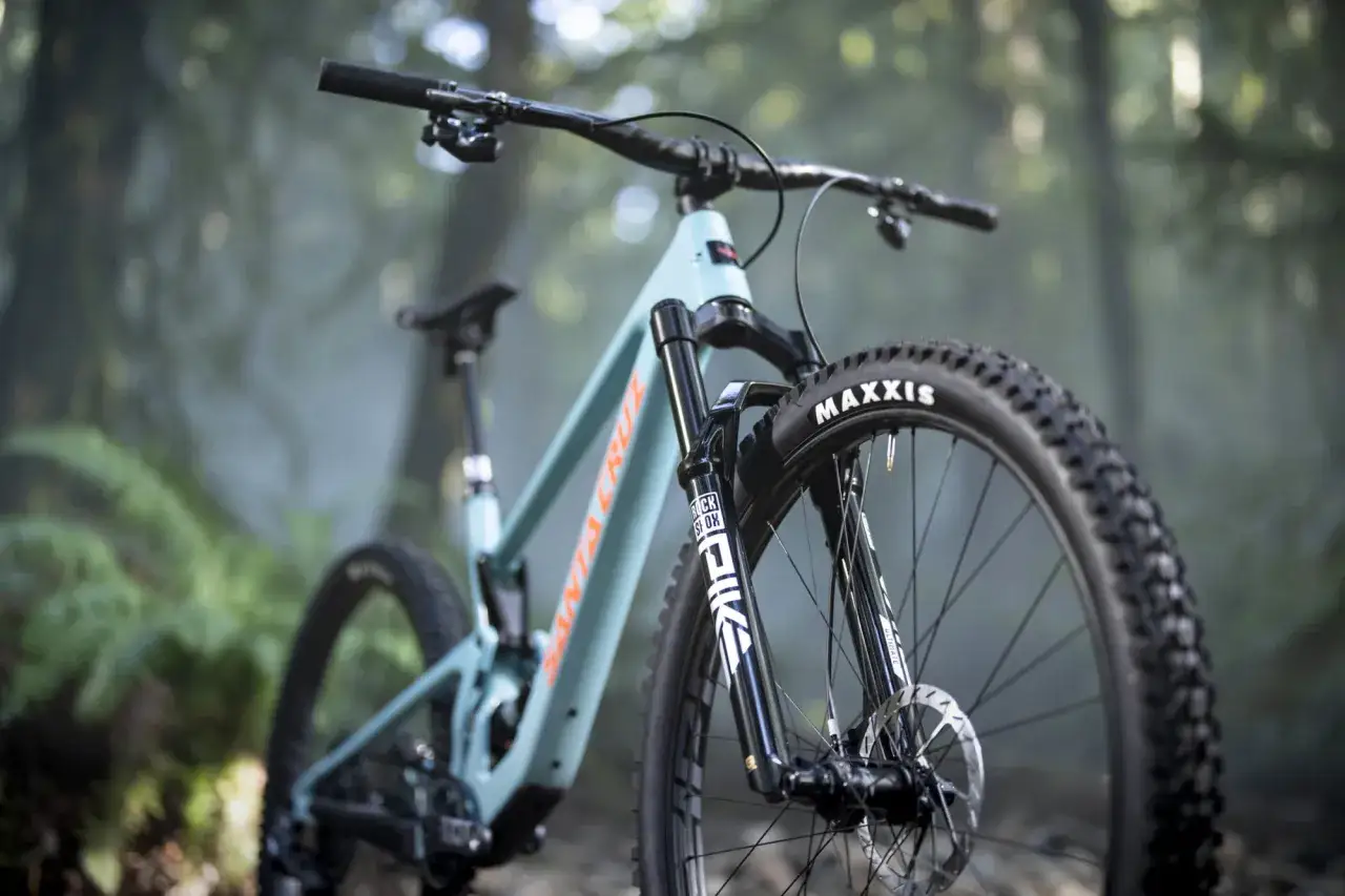 A teal Santa Cruz mountain bike with a RockShox Pike fork, ready for adventure. The rockshox pike weight is optimized for performance.