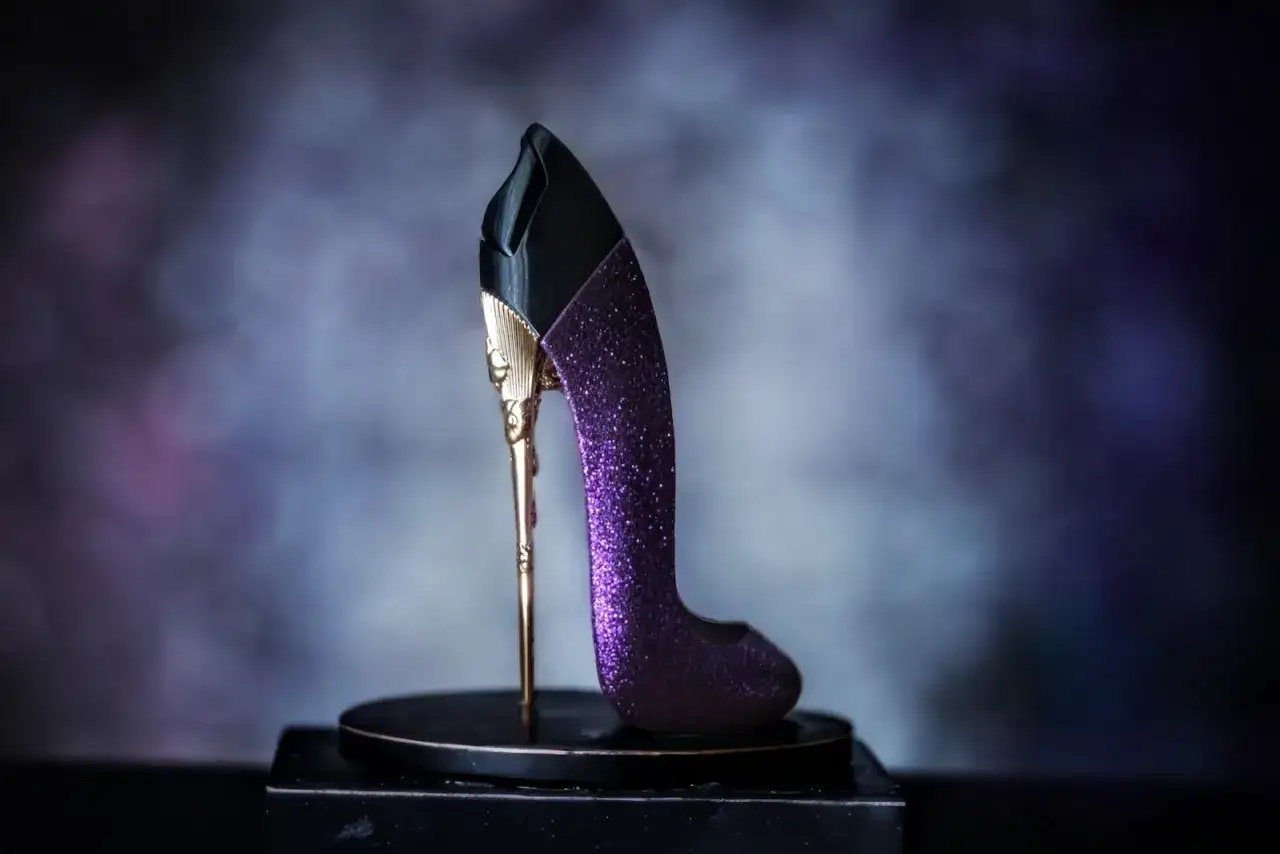 Elegancki, fioletowy, brokatowy but na złotym obcasie z czarną cholewką. Prawdziwy glam Carolina Herrera.