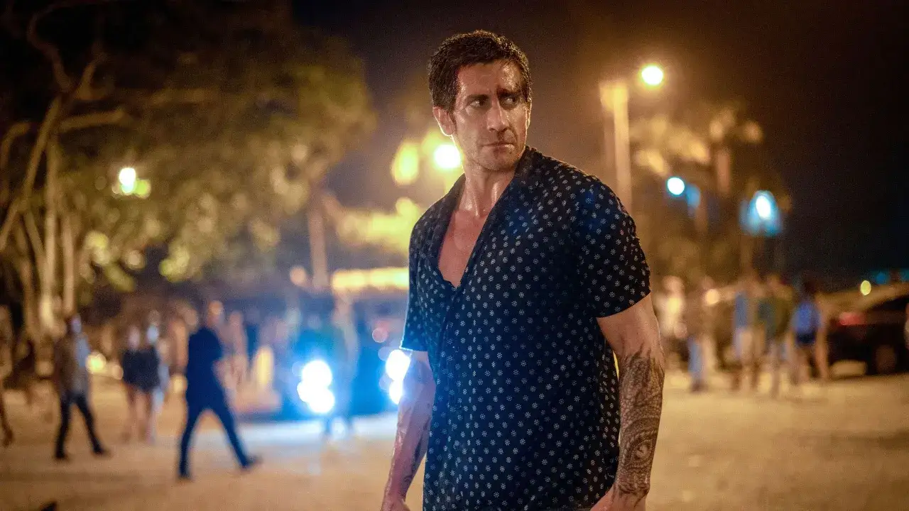 Jake Gyllenhaal w mrocznym filmie, z tatuażem na ramieniu, w nocnej scenerii.