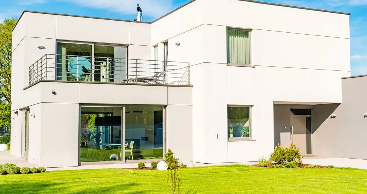 Nowoczesny dom z jasną elewacją w odcieniu **ral7035**, dużymi oknami i balkonem.