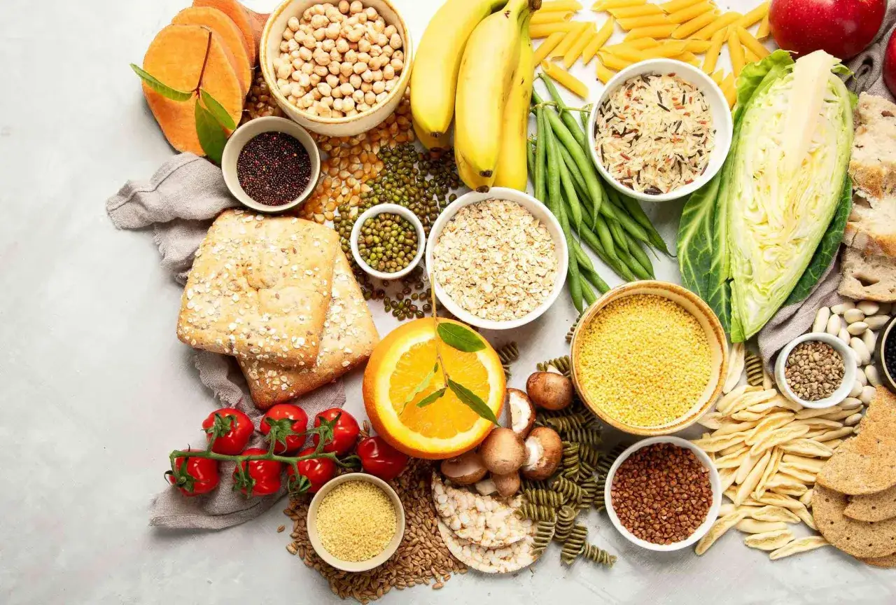 Różnorodne produkty spożywcze: warzywa, owoce, pieczywo, makarony, kasze, nasiona. Czy warzywa to węglowodany? Tak, wiele z nich jest ich dobrym źródłem.