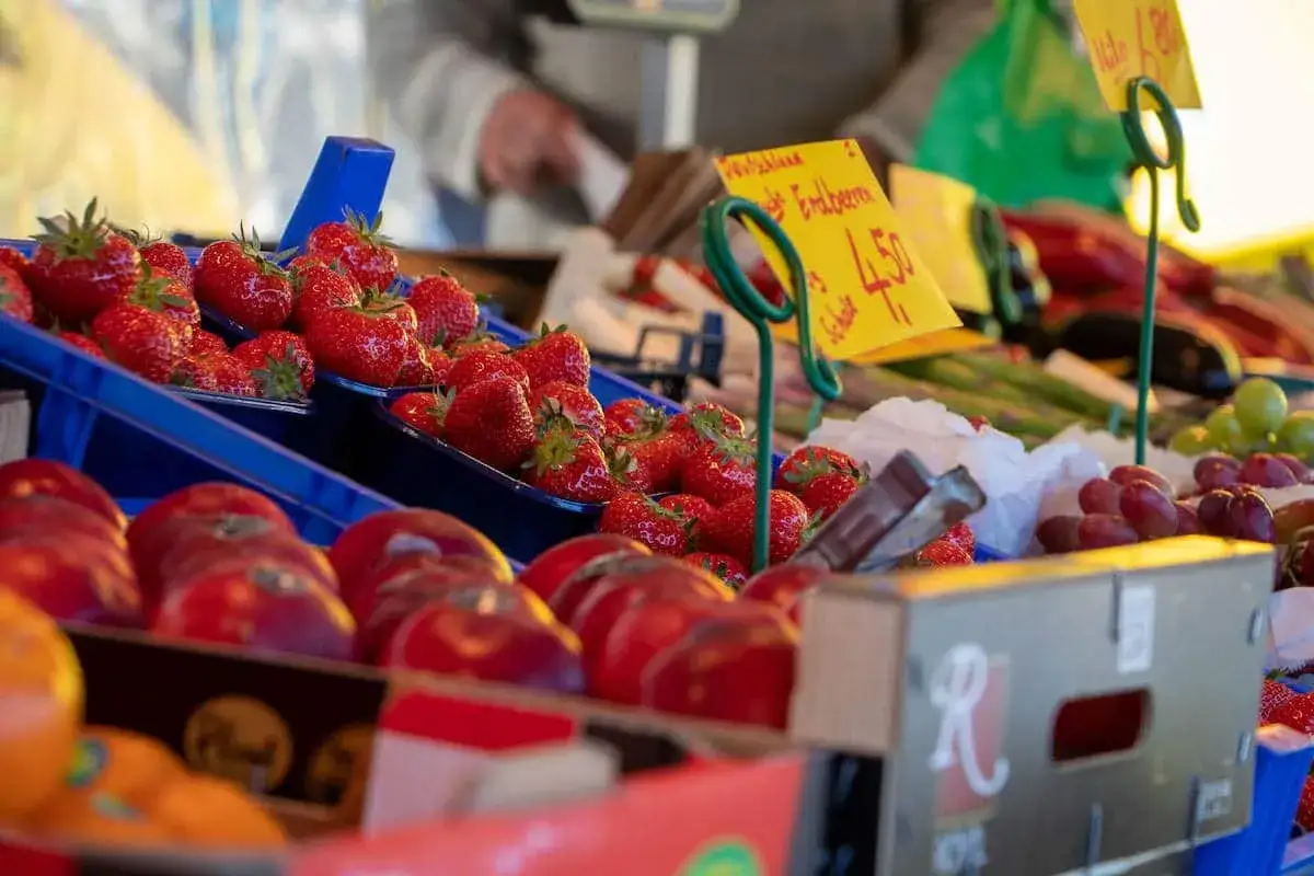 Frische Erdbeeren und Tomaten auf dem Markt Leichlingen. Gelbe Schilder preisen die roten Fr&uuml;chte an.