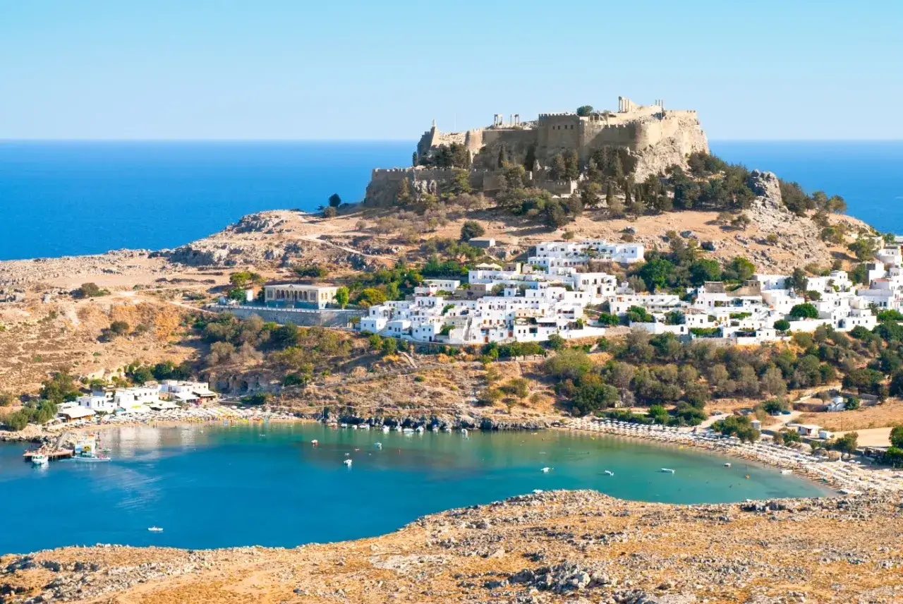 Lindos na Rodos: białe domki, zatoka z łódkami i plażą, a na wzgórzu starożytny akropol. To idealne miejsce, by zobaczyć, co oferuje Rodos.
